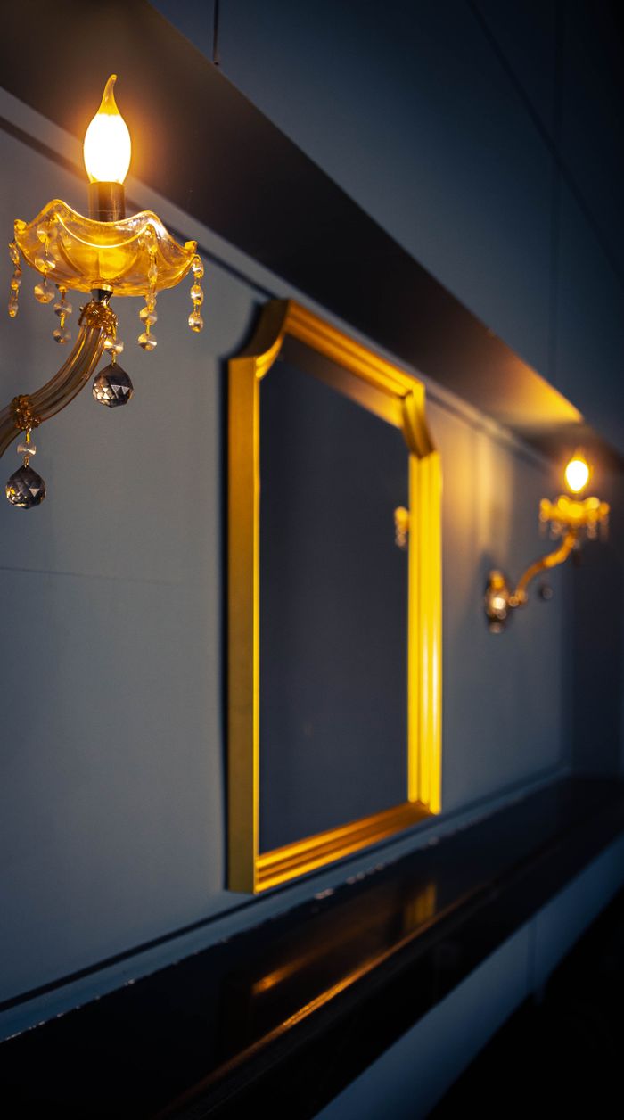 Stylish interior featuring ornate wall lamps and a decorative mirror with warm lighting accent.