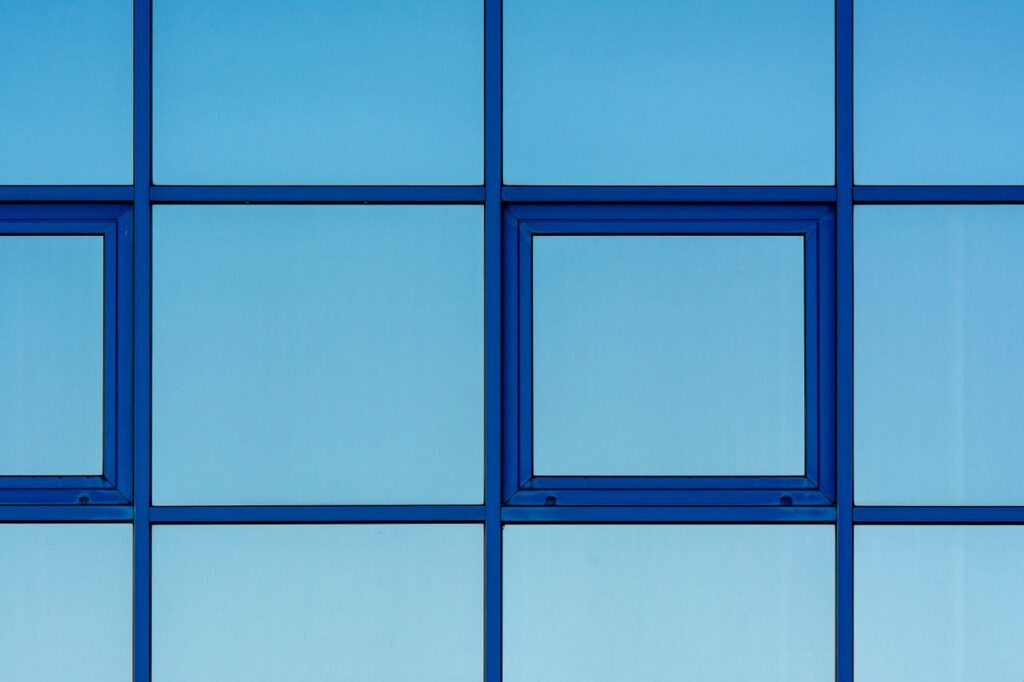 pexels-photo-19354388-19354388 Close-up of a blue building facade with geometric window design highlighting structure and simplicity.