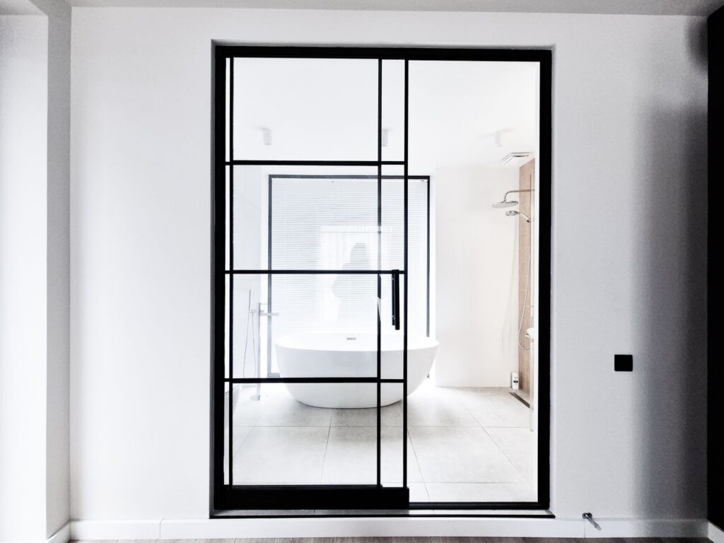 pexels-photo-33652399-33652399 Contemporary bathroom design featuring a sleek freestanding tub and black framed glass doors.