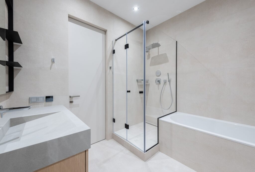 pexels-photo-6588586-6588586 Interior of modern light bathroom with bathtub and shower next to sink with cabinet near door